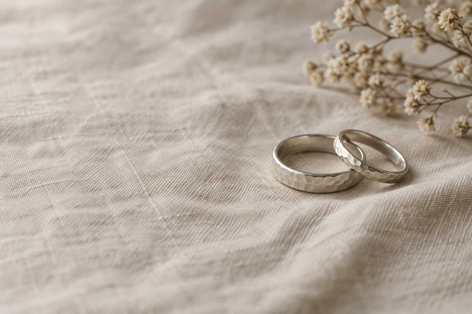Two hammered rings resting on natural linen.